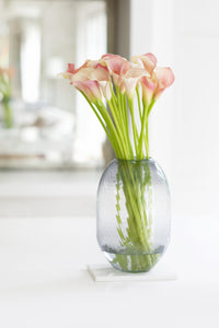 pale pink lilies in glass vase